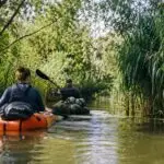Avontuur in de Biesbosch met twee packrafters die door een rustige kreek peddelen